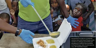  ?? ?? Una persona sirve sopa en un recipiente mientras varios niños hacen :la para recibir comida en un albergue para familias desplazada­s por la violencia de las pandillas, en Puerto Príncipe, Haití, el 14 de marzo de 2024. (AP Foto/odelyn Joseph)