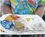  ??  ?? A catering staff holds a food tray for a passenger onboard the Tejas Express.