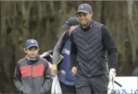  ?? AP photo ?? Tiger Woods walks with his son Charlie, 11, after hitting his tee shot on the 11th hole during a pro-am round of the PNC Championsh­ip on Thursday.