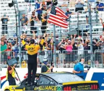  ?? AP PHOTO/CHARLES KRUPA ?? Brad Keselowski celebrates with the American flag after winning Sunday’s race at New Hampshire Motor Speedway in Loudon.