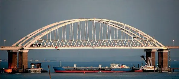  ?? AP ?? A ship under the the Kerch bridge blocks the passage to the Kerch Strait near Kerch, Crimea, after Russia and Ukraine traded accusation­s over an incident at sea.