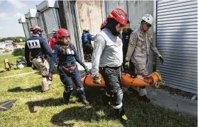  ?? Brett Coomer / Staff photograph­er ?? Emergency responders from Latin America carry a mannequin from a collapsed building during a rescue simulation while training at Disaster City on Wednesday.