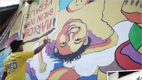  ??  ?? DUNIA TERBALIK: Khoirul Anwar dari Cikal Scout Community Trenggalek membuat mural imbauan untuk menjauhi narkoba.
