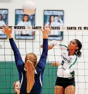  ?? [PHOTO BY NATE BILLINGS, THE OKLAHOMAN] ?? Edmond Santa Fe’s Kaeli Robinson (9) hits the ball over the net as Edmond North’s Sarah Holmes defends during a high school volleyball match Monday night at Edmond Santa Fe.