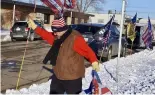  ?? ?? Donald Trump supporter Charles Tuttle, of Minot, sets out a row of Trump flags outside Minot Municipal Auditorium, where voting in the GOP caucus took place 4 March 2024