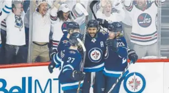  ?? John Woods, The Canadian Press ?? From left, Winnipeg’s Nikolaj Ehlers, Mark Scheifele, Dustin Byfuglien and Patrik Laine celebrate Byfuglien’s goal against the Vegas Golden Knights during the first period of Game 1 of the Western Conference final Saturday in Winnipeg, Manitoba.