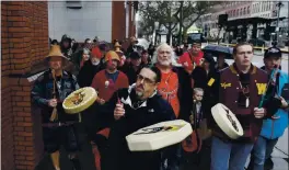  ?? TED S. WARREN — THE ASSOCIATED PRESS FILE ?? Tony A. (Naschio) Johnson, center, chairman of the Chinook Indian Nation, plays a drum as he leads tribal members and supporters to the federal courthouse in Tacoma, Wash., as they continue their efforts to regain federal recognitio­n.