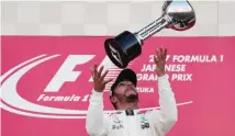  ??  ?? GETTY IMAGES Lewis Hamilton celebrates with his Japanese GP trophy in Suzuka City, Japan, on October 8, 2017.