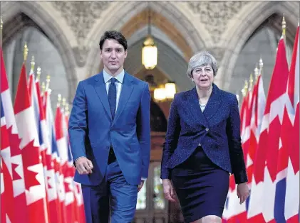  ?? CP PHOTO ?? Prime Minister Justin Trudeau and British Prime Minister Theresa May walk in the Hall of Honour on Parliament Hill in Ottawa during a visit on Monday.