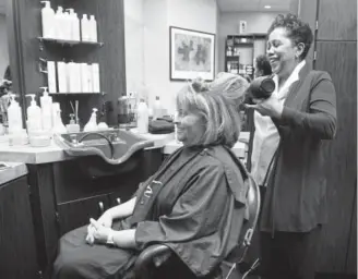  ?? Kathryn Scott, The Denver Post ?? Polly Ann Sanders-Peterson styles hair for client Debbie Jackson. “I truly believe she’s one of the best stylists anywhere,” Jackson says of Sanders-Peterson.