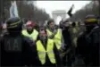  ?? KAMIL ZIHNIOGLU - THE ASSOCIATED PRESS ?? Yellow vest protesters walk down the famed Champs Elysees avenue to keep pressure on French President Emmanuel Macron’s government, for the 13th straight weekend of demonstrat­ions, in Paris, France, Saturday, Feb. 9.