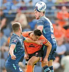  ?? GETTY IMAGES ?? Rahmat Akbari squeezes between Scott Wootton and Tim Payne to give Brisbane Roar an early lead against Wellington Phoenix.