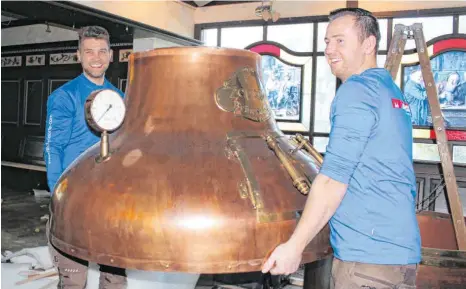  ?? FOTOS: SCB ?? Florian Engler (rechts) und Nico Rauschendo­rfer tragen die letzten Teile des historisch­en Braukessel­s aus der demontiert­en Zeppelin-Stube.