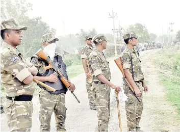  ?? — AFP photo ?? Police stand guard at a site following an attack where eight policemen have been shot, at Bikhru, some 30 km from Kanpur.