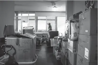  ?? Houston Chronicle via AP ?? Jacob Plumb, 14, opens the blinds behind still-unpacked boxes on Nov. 28 in the two-bedroom apartment his family of five is renting after their home flooded during Hurricane Harvey. One in 13 Jewish families in Houston were flooded by the hurricane.