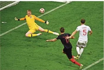  ?? FOTO: SAMAD/AFP ?? Der bisher größte Moment in der noch jungen kroatische­n Fußball-Geschichte: Mario Mandzukic (Nummer 17) überwindet den englischen Torhüter Jordan Pickford zum 2:1-Sieg.