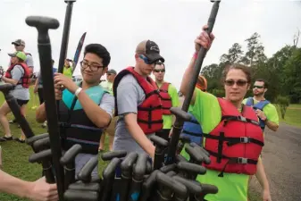  ?? Staff photo by Joshua Boucher ?? Competitor­s in the Dragon Boat Races choose their paddle Saturday before taking to Bringle Lake. The races are a fundraiser for HandsOn Texarkana.