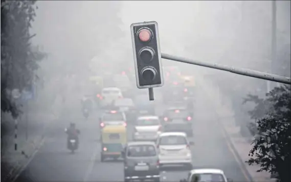  ??  ?? Health hazard: Traffic during heavy fog in Delhi. Air pollution has damaged the lungs of half the city’s children.