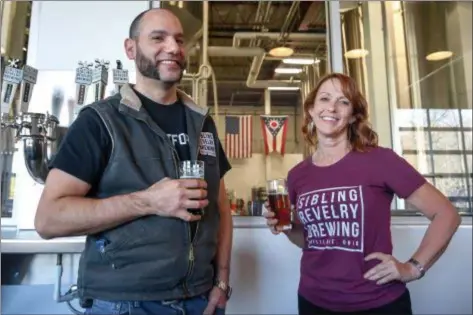  ?? ERIC BONZAR — THE MORNING JOURNAL ?? Head Brewmaster Pete Velez and Sales and Marketing Director Carol Sanders enjoy a pint of craft beer in the taproom of Sibling Revelry Brewing, 29305 Clemens Road, in Westlake.