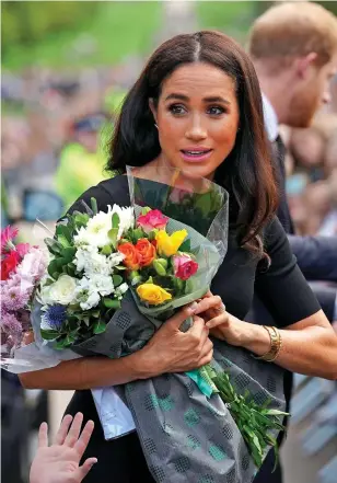  ?? ?? ROYAL ROSES: Meghan clutches bouquets from well-wishers