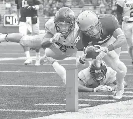  ?? Young Kwak Associated Press ?? WASHINGTON STATE receiver Tavares Martin Jr. dives for the pylon to score on a 19-yard pass play for the Cougars’ final touchdown against Nevada.