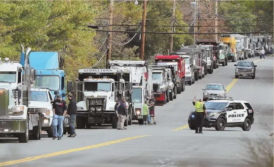  ?? HERALD PHOTO BY MARK LORENZ ?? MOVING SIGHT: A long line of trucks gets into formation on Jackman Street in Georgetown yesterday before parading past Tommy Cook’s house to celebrate the remission of the 4-year-old’s liver cancer. More than 40 trucks were joined by fire and police...