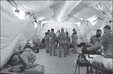  ?? ?? MEDICAL TENT (right)—Nome Volunteer Ambulance staff speak with exercise participan­ts inside the prototype medical tent.