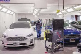  ??  ?? A paint technician works on a vehicle at Car Crafters, 600 Montaño NE.