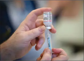  ?? (File Photo/AP/Pool/Leon Neal) ?? Medical staff and volunteers prepare shots of the covid-19 vaccine Dec. 16 at a vaccinatio­n center in Ramsgate, England.