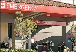  ?? DAMIAN DOVARGANES / AP FILE ?? In this Dec. 18 file photo, an unidentifi­ed patient receives oxygen on a stretcher as Los Angeles Fire Department paramedics monitor him while waiting for admission outside the Emergency Room entrance at CHA Hollywood Presbyteri­an Medical Center in Los Angeles.