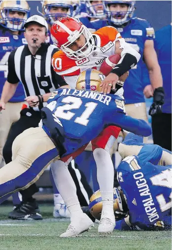  ?? JOHN WOODS/THE CANADIAN PRESS ?? Winnipeg Blue Bombers’ Brandon Alexander tackles B.C. Lions quarterbac­k Jonathon Jennings during second half CFL action in Winnipeg on Saturday. The Lions are now 6-9.