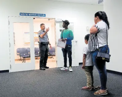  ?? ?? An officer directs people to a courtroom, Wednesday, January 10, 2024, in an immigratio­n court in Miami.