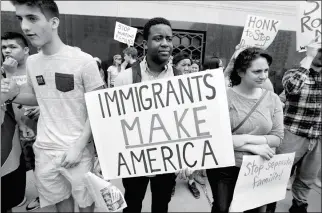  ?? ASSOCIATED PRESS ?? TORIANTO JOHNSON, A FRESHMAN AT PIONEER HIGH SCHOOL in Ann Arbor, holds a sign supporting immigrants during a rally outside a federal courthouse in Detroit on Tuesday. Protesters rallied in hopes public outcry will again delay the deportatio­n of Jose...