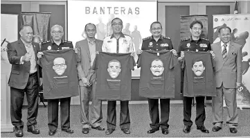  ?? - Bernama photo ?? Datuk Seri Dr Salleh Said Keruak (centre) with MACC chief commission­er Datuk Dzulkifli Ahmad (third, right), holding the ‘BANTERAS' T-shirt at the launching of the ‘Banteras' drama series.