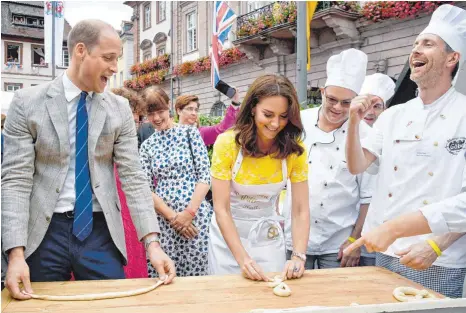  ?? FOTO: DPA ?? Beherzter Versuch: Prinz William und seine Frau Herzogin Kate formen – zur Freude von Bäcker Andreas Göbes (rechts) – Brezeln.