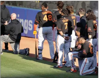  ?? (AP/Ben Margot) ?? Jaylin Davis and Antoan Richardson (lower right) of the San Francisco Giants kneel during the national anthem before an exhibition game against the Oakland Athletics on Monday in Oakland, Calif. Davis said he and his teammates discussed the move before summer camp started. “We wanted it known that we wren’t going to let everything be pushed aside just because baseball is back,” Davis said.