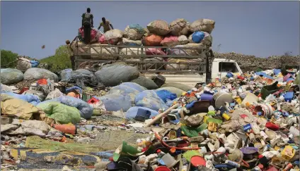  ??  ?? TRASHY JOB: Ivorian men pack bags of plastic bottles onto a truck for recycling from the general waste at the Akouedo recycling depot and landfill site in Abidjan, Ivory Coast. Some government­s have plans to ban other forms of problemati­c plastics, for...