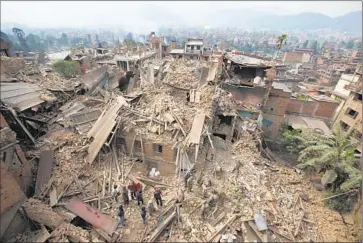  ?? Niranjan Shrestha
Associated Press ?? IN BHAKTAPUR, near Katmandu, workers search for victims the day after a magnitude 7.8 quake in Nepal. Rescuers were still struggling to reach remote villages, some of which can be accessed only by foot trails.