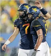  ?? [AP PHOTO] ?? West Virginia quarterbac­k Will Grier (7) celebrates with wide receiver Marcus Simms (8) after they teamed up on a pass against Youngstown State on Saturday.