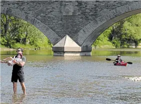  ?? NATHAN DENETTE THE CANADIAN PRESS ?? People enjoy the cool water of the Humber River on a warm, sunny Monday in Toronto.