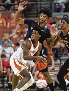  ?? ERIC GAY/ASSOCIATED PRESS ?? Texas guard Marcus Carr looks to pass ahead of West Virginia forward Isaiah Cottrell (rear) on Saturday in Austin, Texas. Carr scored a season-best 20 points in Texas’ 74-59 win in the Big 12 opener.