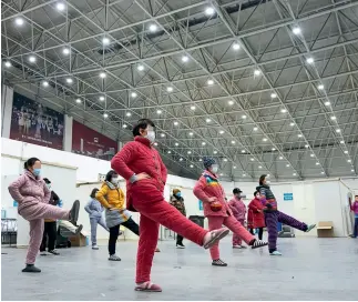  ?? Xinhua ?? 10 de febrero de 2020. Pacientes hacen ejercicios bajo la instrucció­n de médicos en un hospital acondicion­ado de Wuhan.