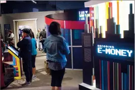  ?? Herald photo by Greg Bobinec ?? Visitors at the Galt Museum &amp; Archives wander through the new exhibit Decoding E-Money, which runs until Jan. 6, 2019.