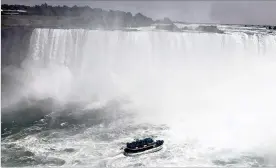  ??  ?? Slicker-clad visitors aboard a Maid of the Mist vessel venture close to Niagara Falls. About 600 people pack onto the boats for a death-defying, waterlogge­d close encounter with the falls during tourist season.