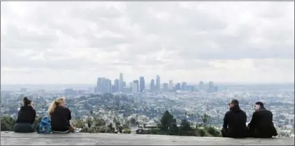  ?? AP PHOTO/CHRIS PIZZELLO ?? Two pairs of hikers maintain distance as they mingle at Vista View Point in Griffith Park, on Friday, in Los Angeles.