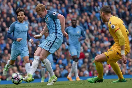  ?? — AFP ?? Manchester City’s Kevin de Bruyne (centre) scores in their English Premier League match against Crystal Palace at the Etihad Stadium on Saturday. Manchester City won 5-0.