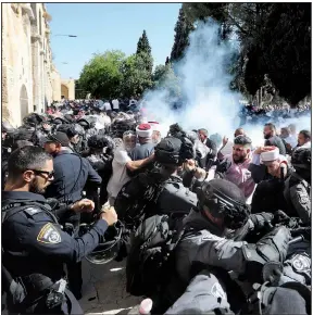  ?? AP/MAHMOUD ILLEAN ?? Tear gas rises Sunday as Israeli police and Muslim worshipper­s clash at a holy site in Jerusalem. The worshipper­s were at the site, called the Al-Aqsa Mosque compound by Muslims and the Temple Mount by Jews, for prayers marking the Islamic holiday of Eid al-Adha. The clashes began after rumors circulated that Jewish visitors would be allowed to enter the site.