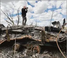  ?? Pete Keihart / Contribute­d photo ?? Getty Images special correspond­ent John Moore takes photograph­s from a former frontline position on the outskirts of Kharkiv, Ukraine, on May 16.