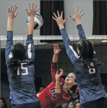  ?? Jayne Kamin-Oncea/For The Signal ?? Santa Clarita Christian’s Kalona Marr, center, hits the ball while Trinity’s Hannah Rapier (15) and Kathryn Brooks (8) reach for the block. SCCS won 3-1.