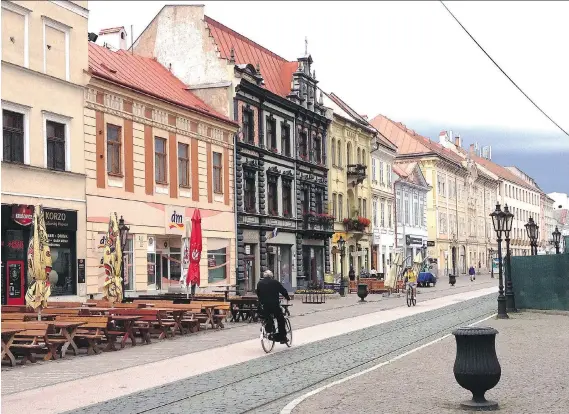  ?? PHOTOS: ERICA ROSENBERG/THE WASHINGTON POST ?? Early-morning cyclists ride down Hlavna Ulica (Main Street) in Kosice, Slovakia. The street’s cafes are bustling most other times of day.